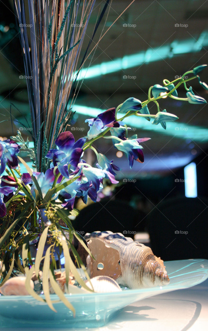 Blue orchids and seashells in an event centerpiece 