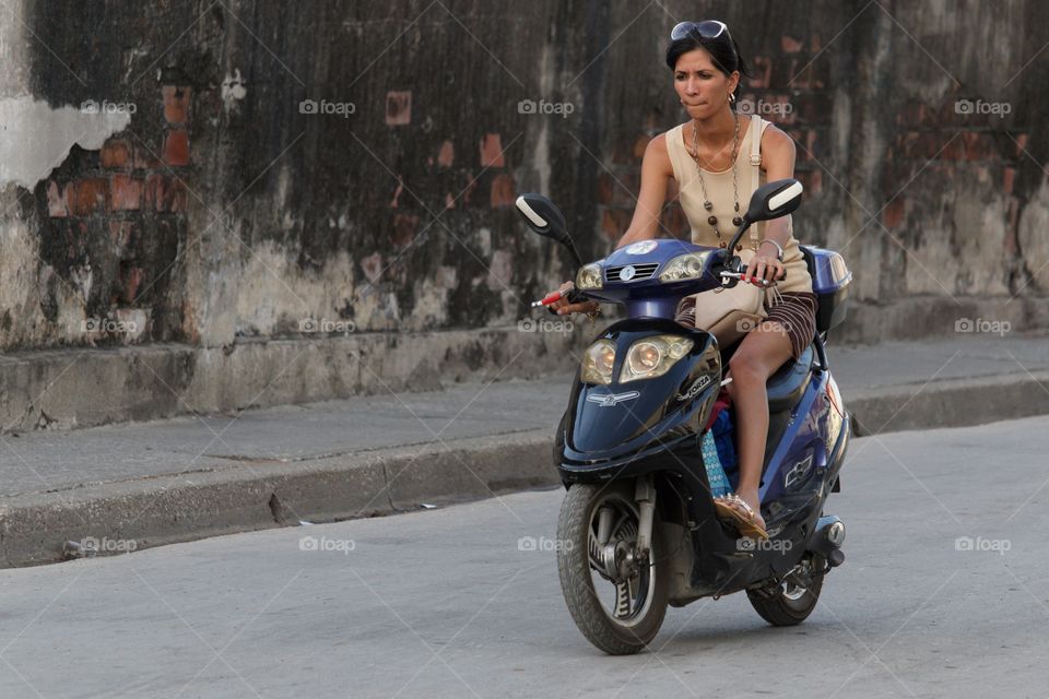 Cuban People.Woman on moped