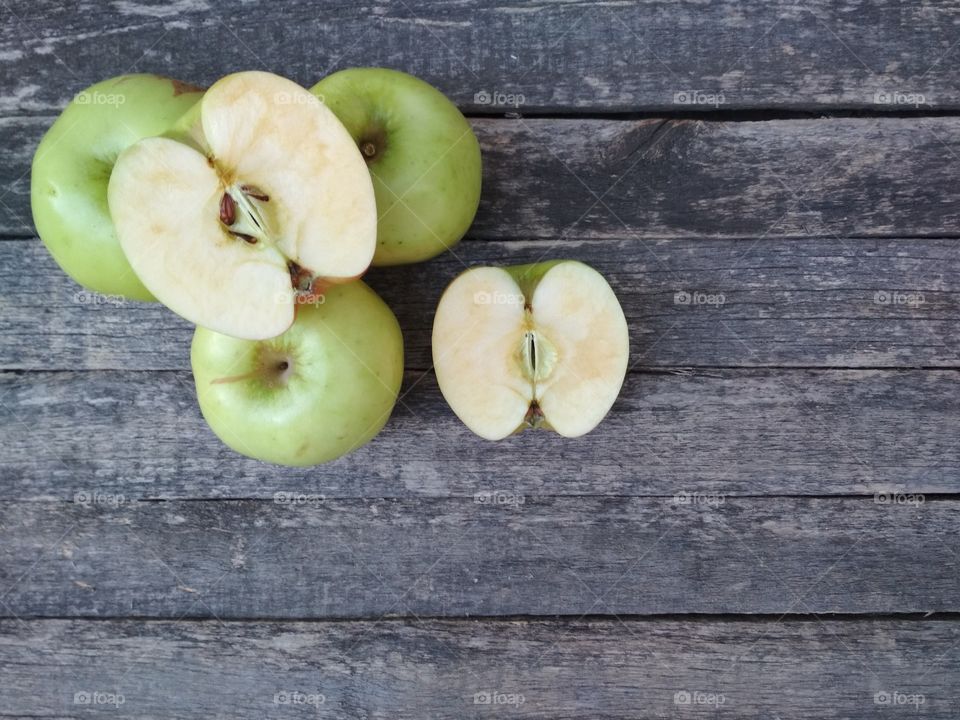 Green apples on aged wooden background.