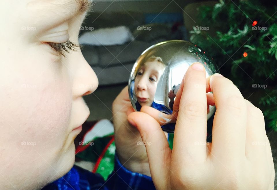 Close-up of a boy holding Christmas bauble in hand