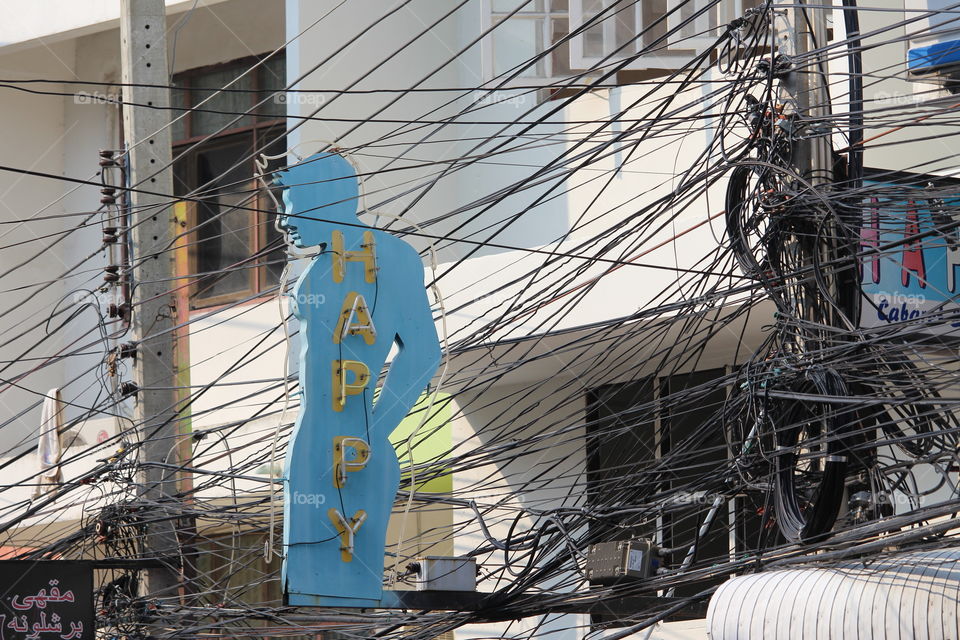 Happy sign amidst wires
