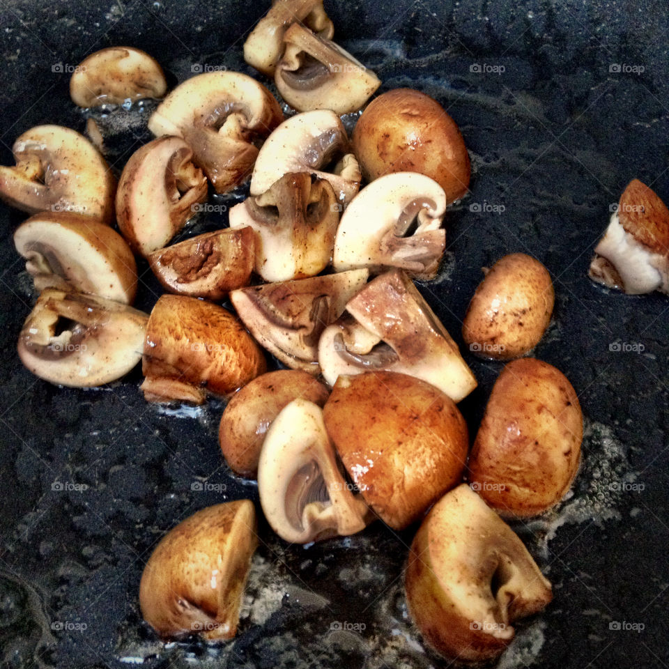 Small Portobello Mushrooms Cooking In A Frying Pan Skillet
