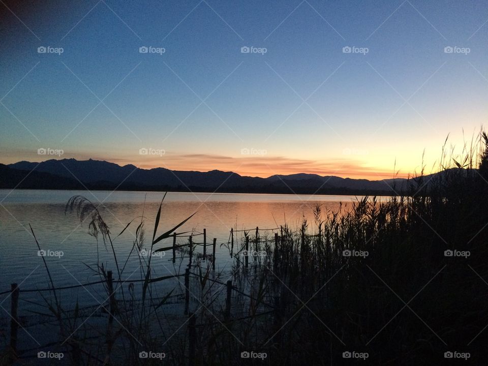 Idyllic view of lake with silhouetted mountain