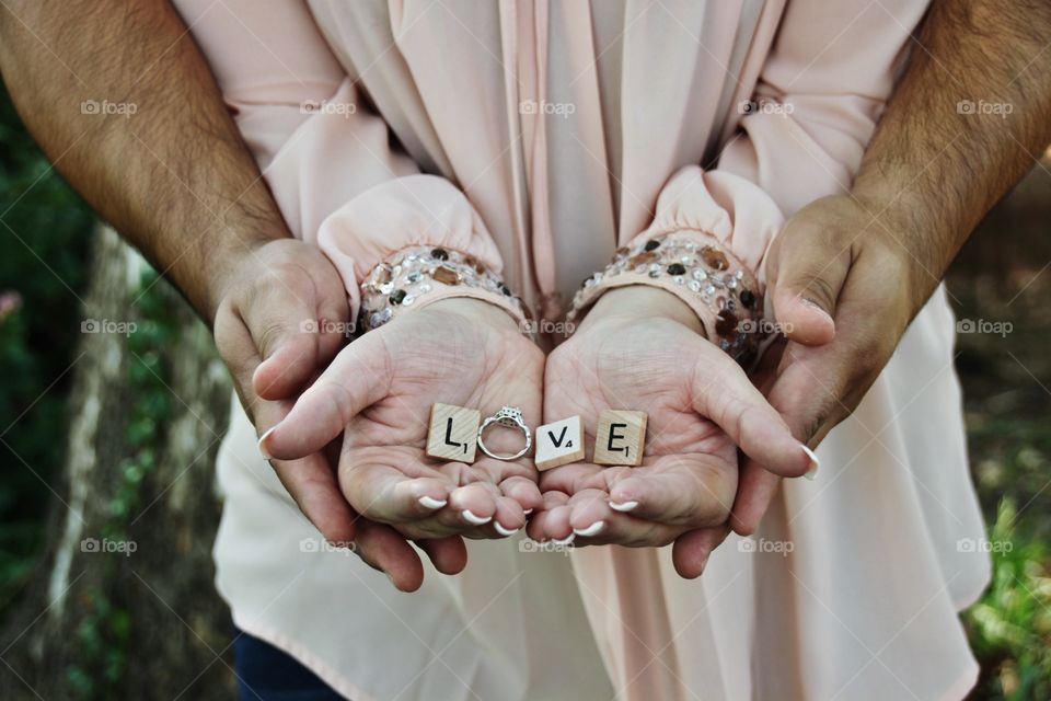 Love expressed on tiles spelling out love with the brides  engagement ring in the couples hands! 