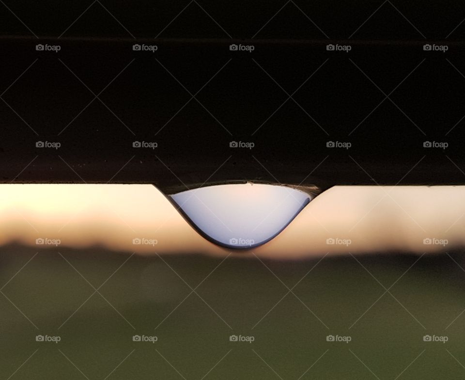 Reflections in a waterdrop at sunset.