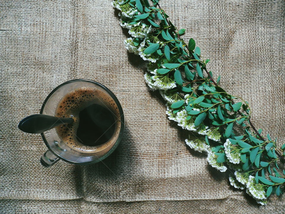 A cup of coffee and a bouquet of flowers