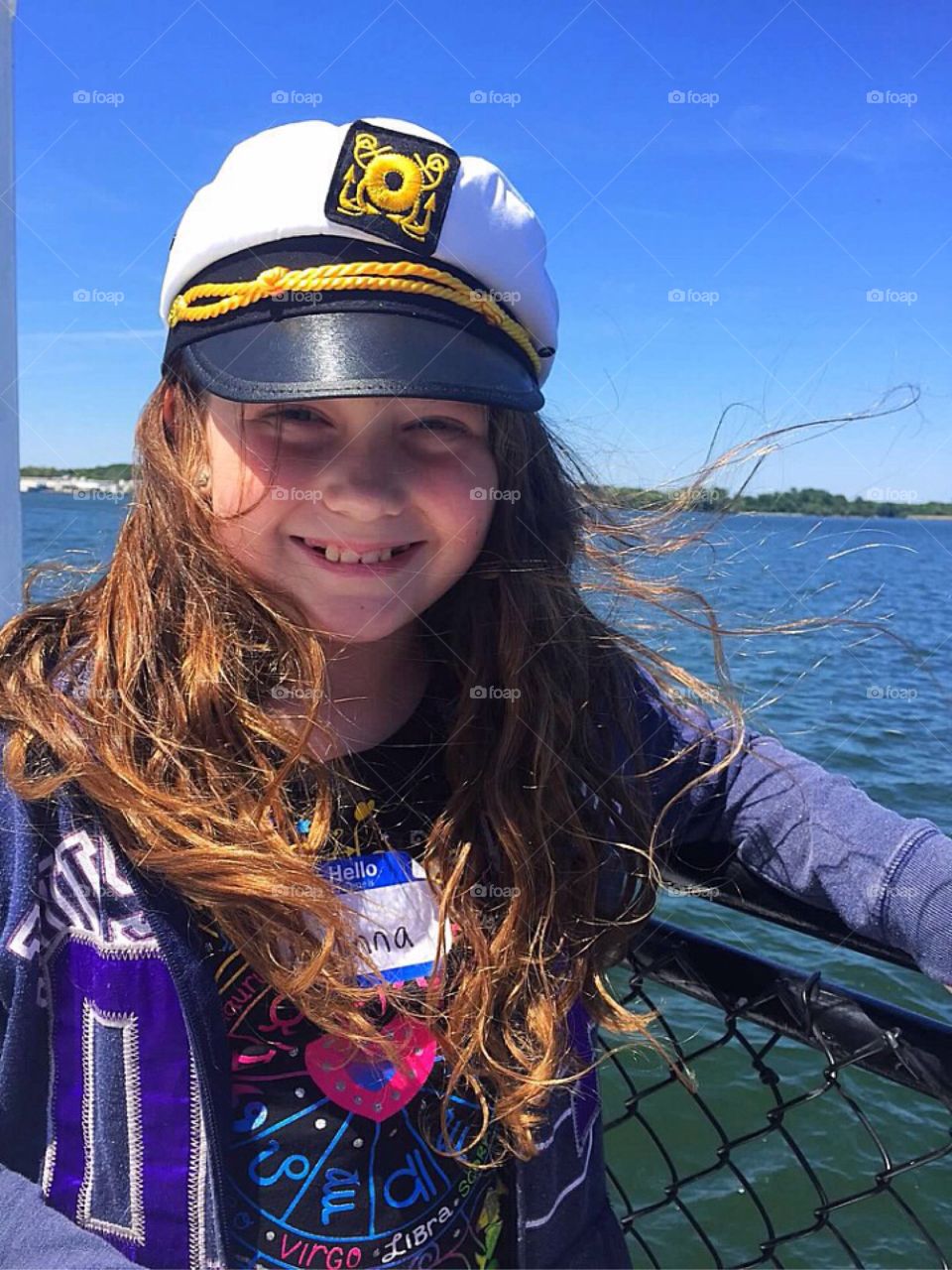 A young girl being a captain of a ship. 