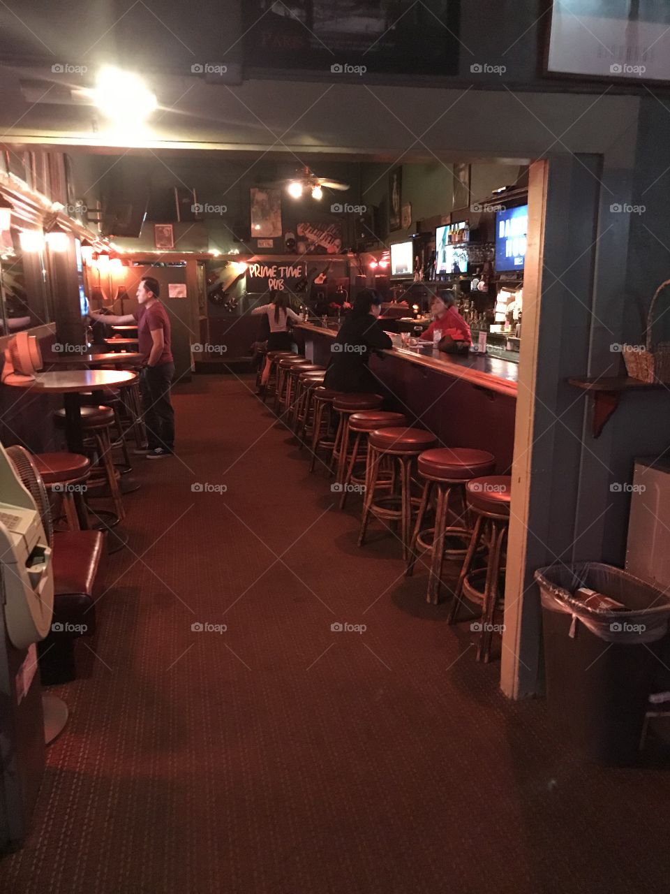 Interior of a dark and dingy dive bar sparsely populated by lonely people getting drunk on a sad Tuesday night. 