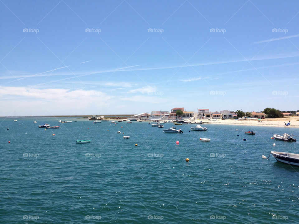 Sunny beach with boats and sea
