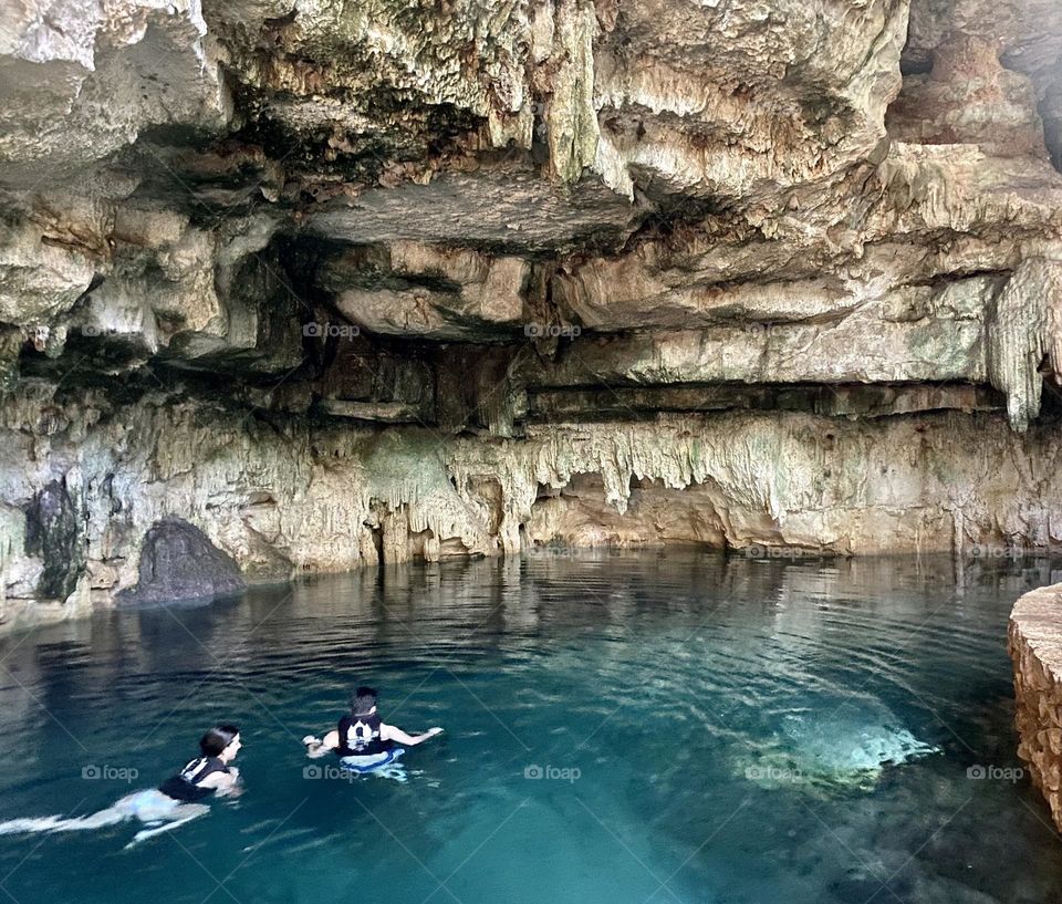 Two people swimming in a Mayan cenote in Mexico