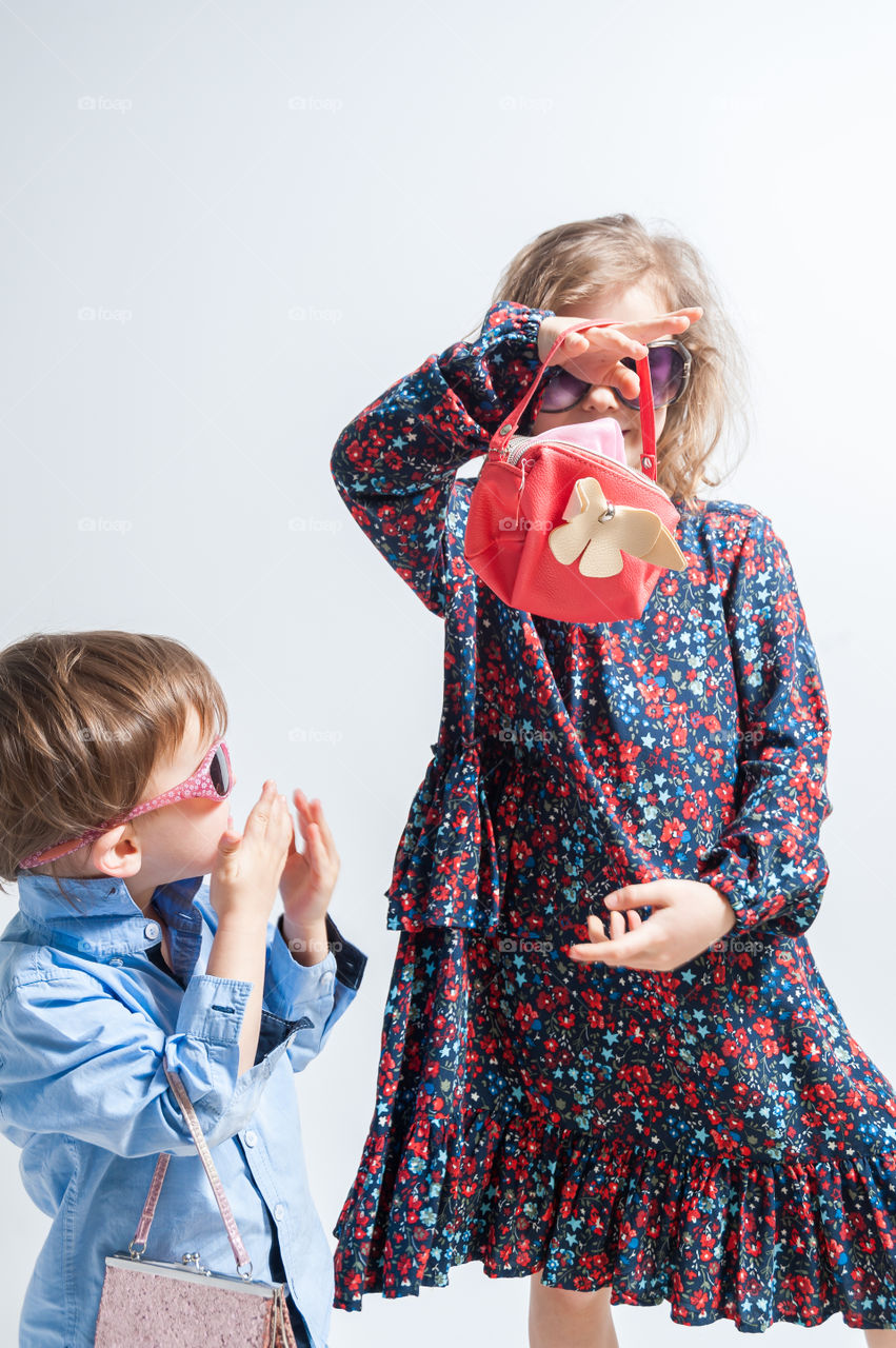 Children having fun playing fashion with handbags.