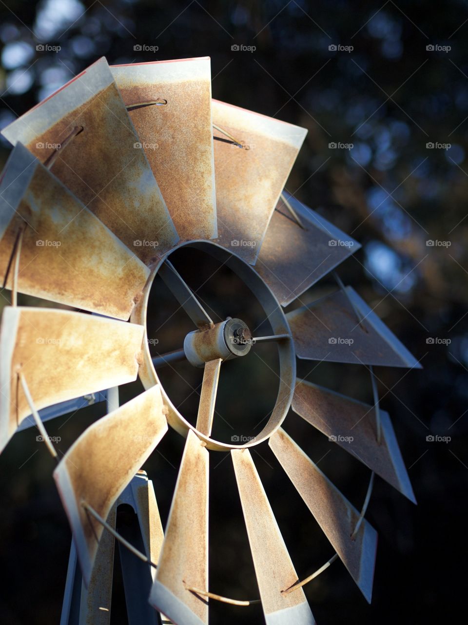 An old and rusted farm windmill in during evenings beautiful light in Central Oregon on a winter day. 