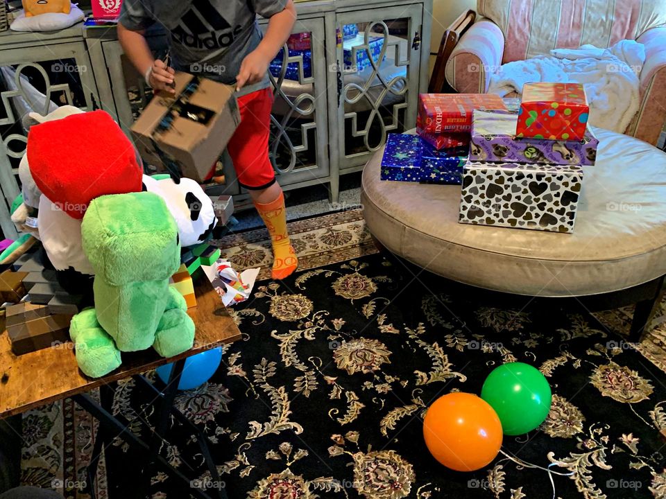 Gifting Season - A young boy is surprised on Christmas morning as he opens toys from Santa Claus