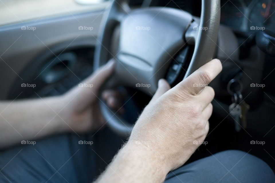 Mans hands on steering wheel 