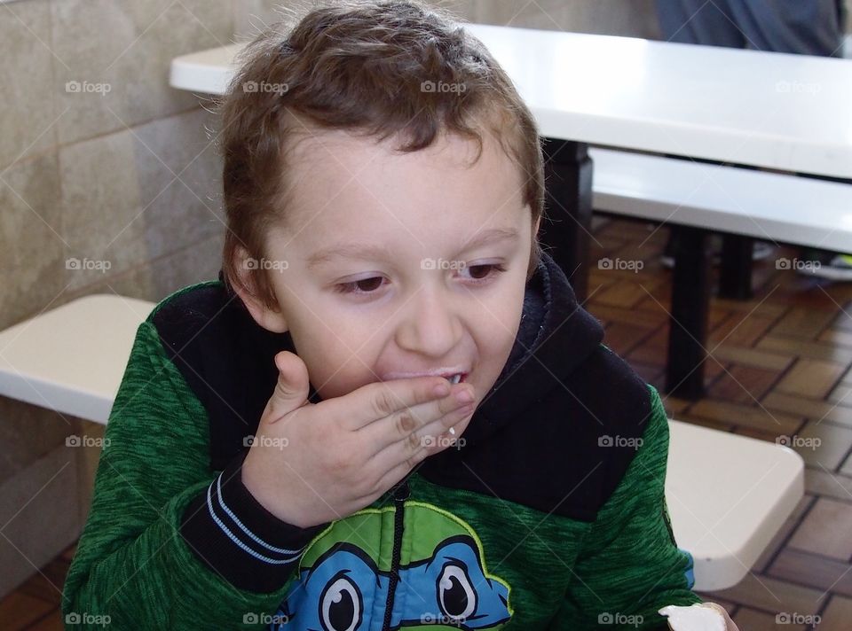 A little boy finishes one of his favorite treats....a vanilla ice cream cone. 