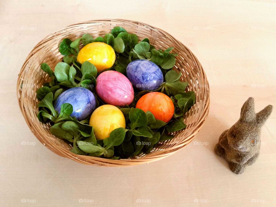 colorful Easter eggs in a basket and an Easter bunny