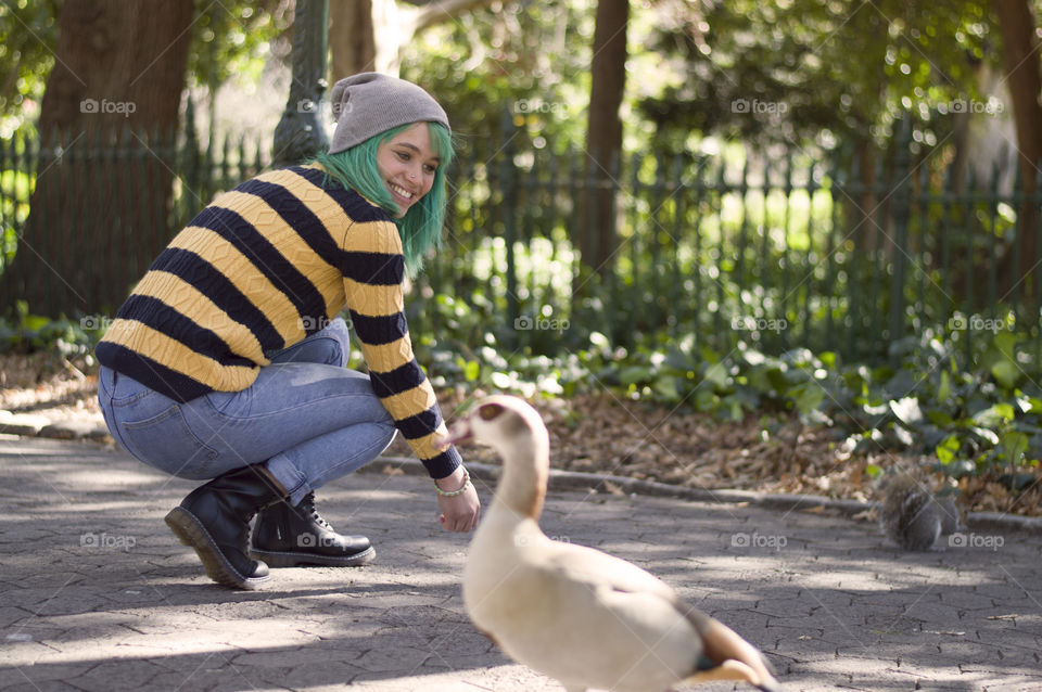 Alternative girl smiling green hair Egyptian goose in the park