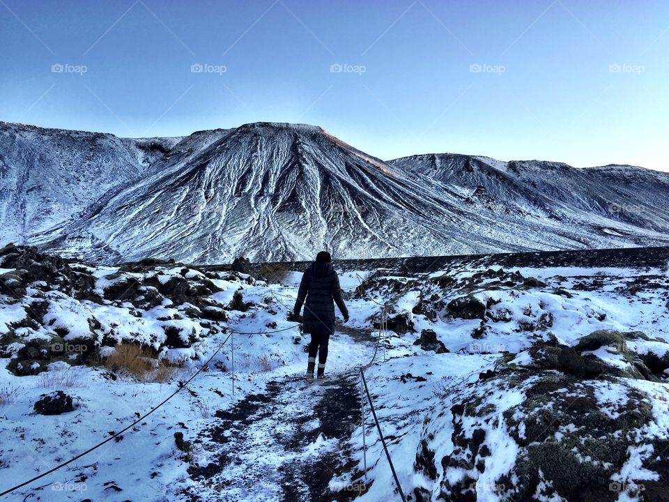 Rear view of woman walking on snowy landscape