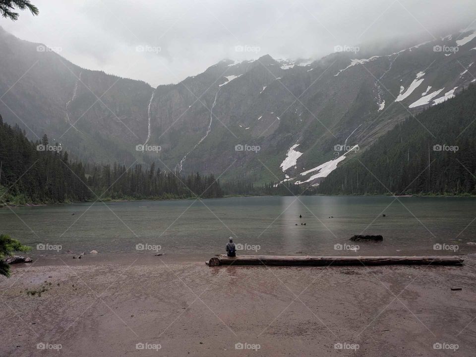 Sitting Alone on a Misty, Gloomy, Rainy Day at Avalanche Lake in Glacier National Park in Montana