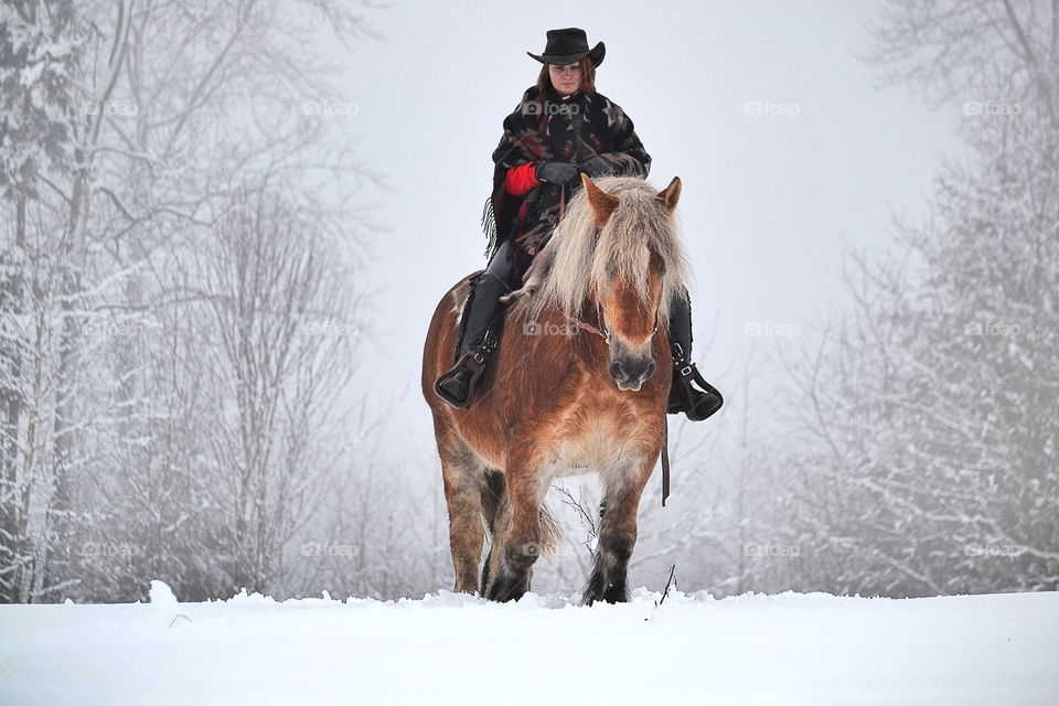 Woman horseback riding in winter