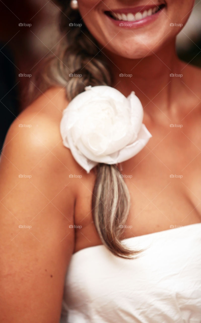 Woman with braid and flower detail holding hair