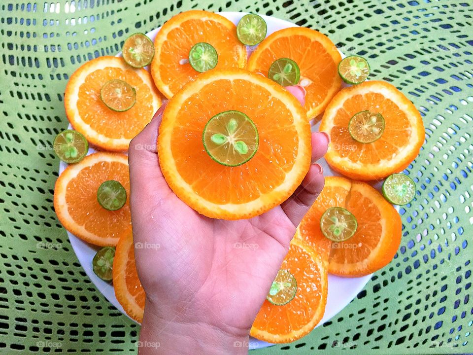 A hand holding an orange