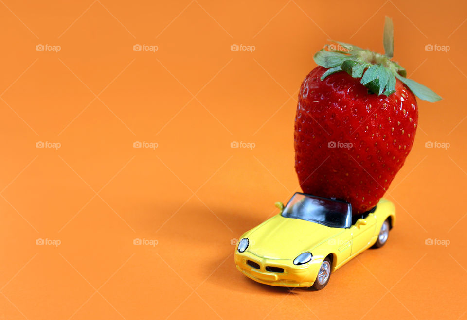 Colorful summer trip, a strawberry in a toy car