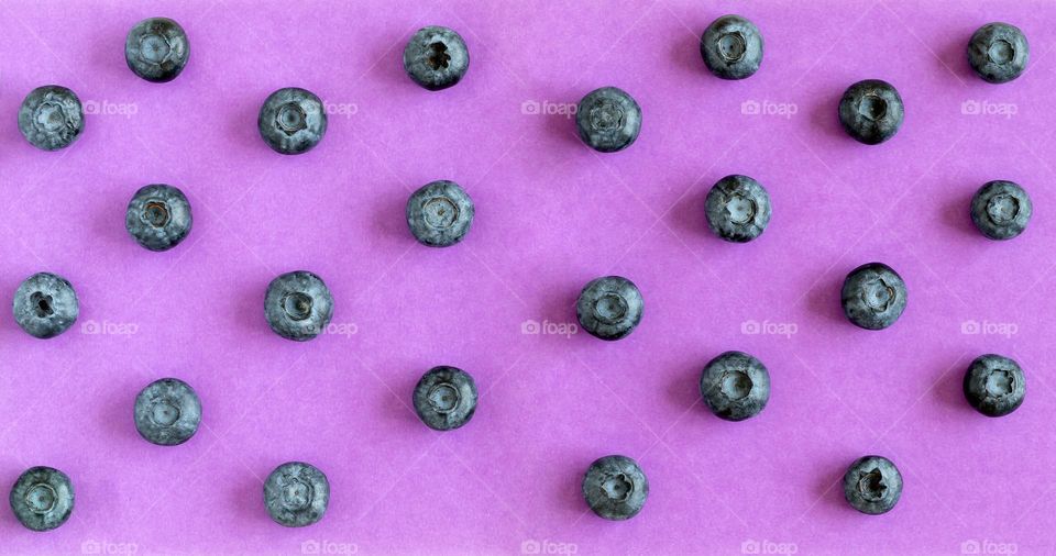 Blueberries on purple background, top view flatlay