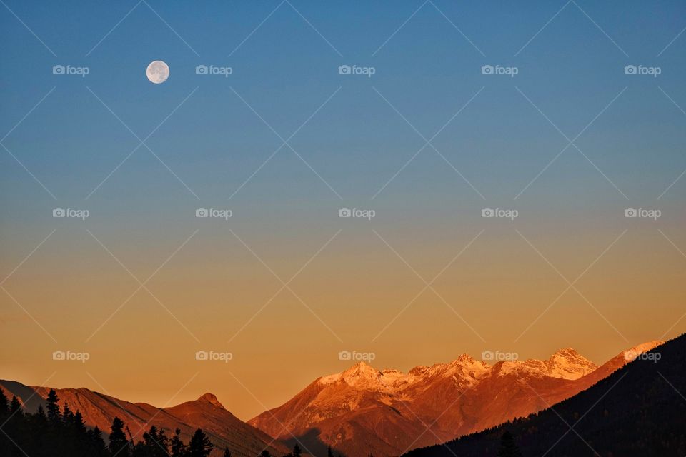 Moon in morning twilight over beautiful mountain scape at Georgia countryside 