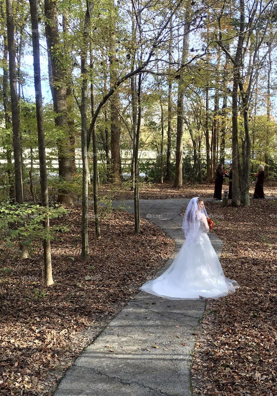 Bride stopping to reflect on the beauty surrounding her before heading off to say her vows. 