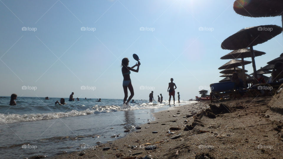 people playing beach ball besides sea