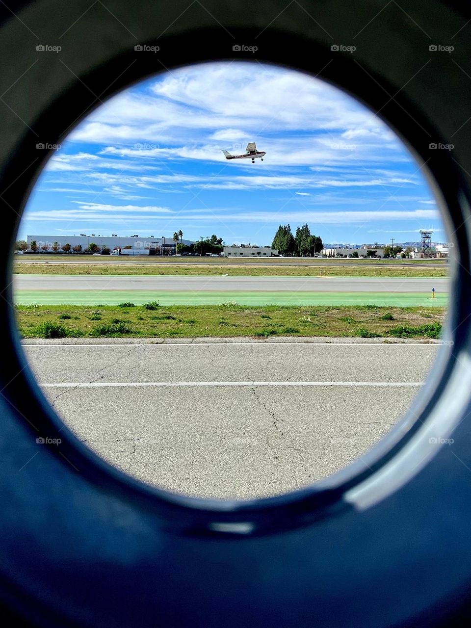 Watching a plane takeoff from Van Nuys Airport (VNY) from a viewing hole in the gate at the Van Nuys Airport Observation Area