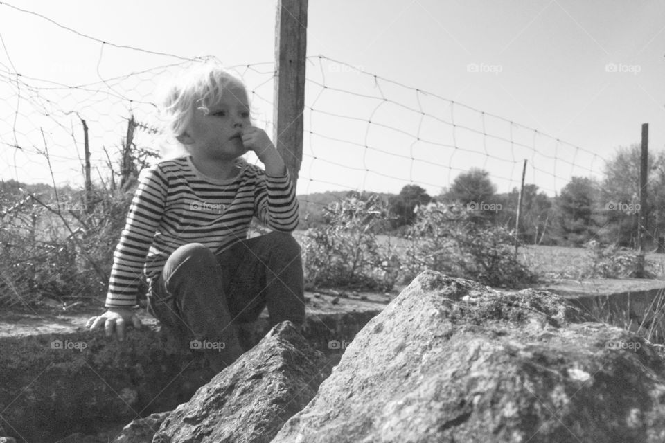 Boy sitting on a wall on a farm