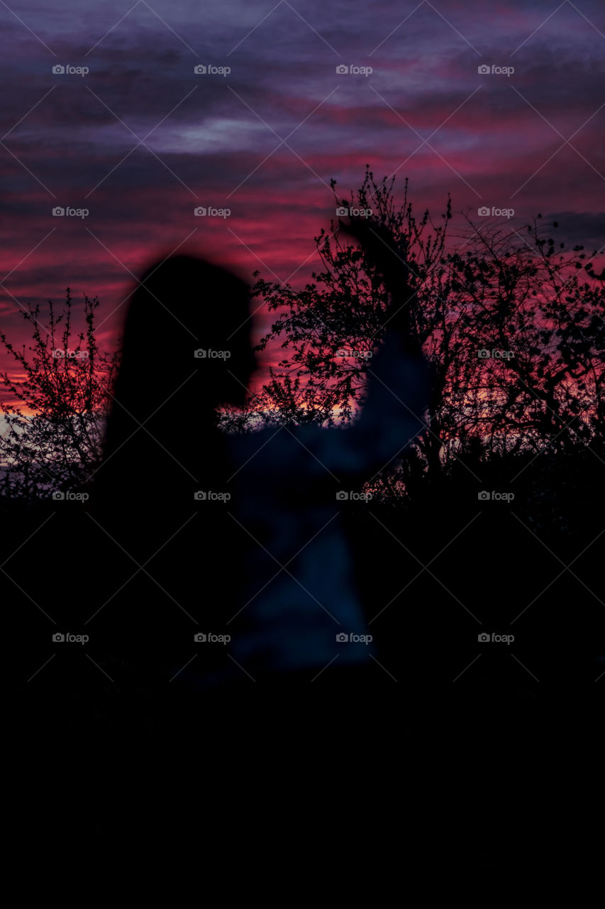 Blurred silhouette of person at background of sunset.