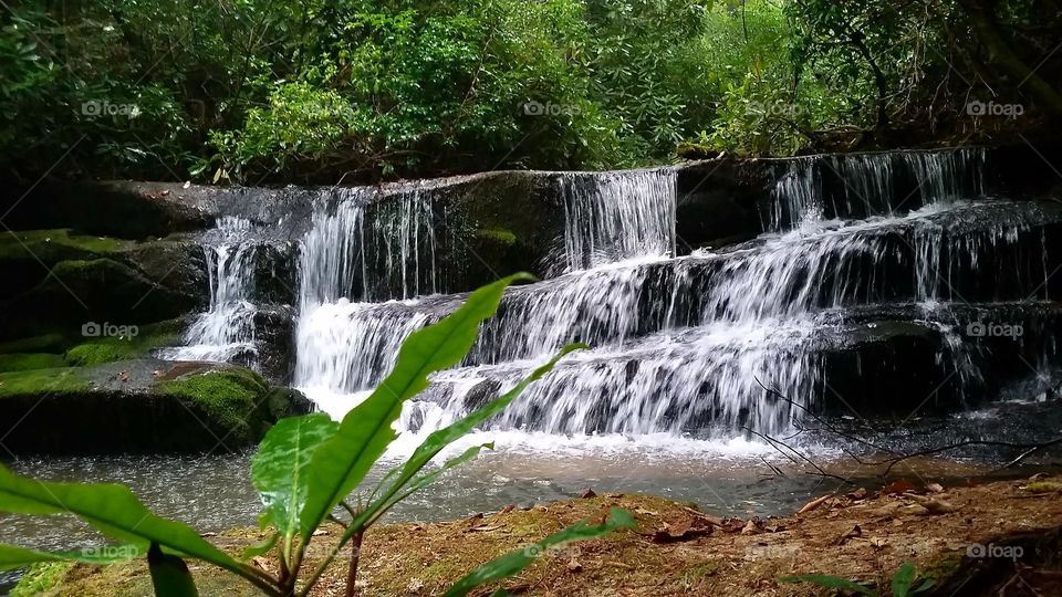 Small waterfall on Crow creek surrounded with lush greenery in Georgia