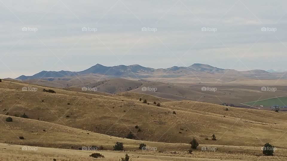 mountains in the distance. a view of distant mountains over spurs and draws