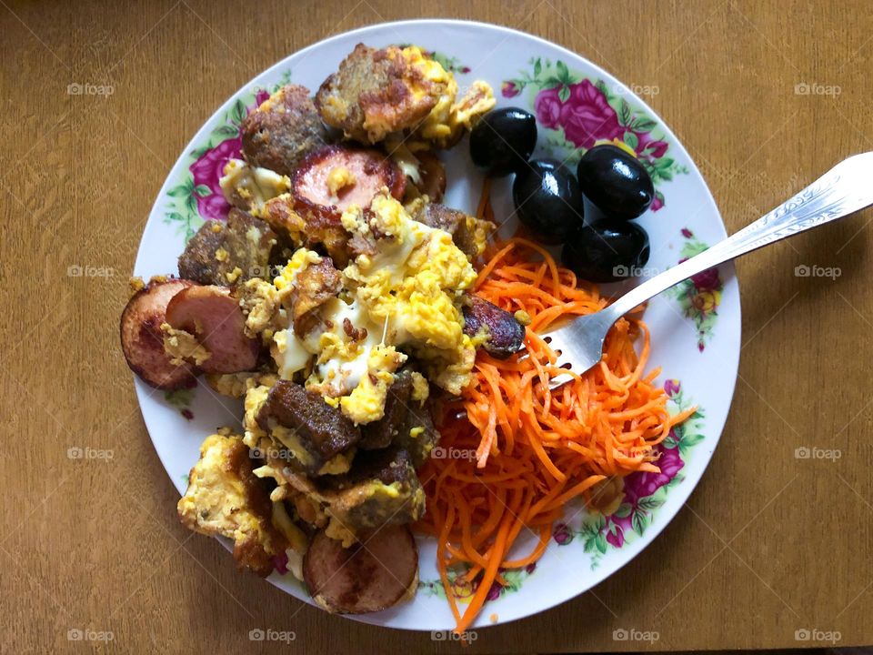 omelet with sausages, croutons, cheese, olives and carrots