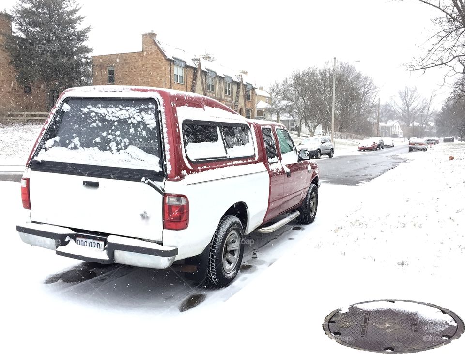 Red and white pickup truck in snow