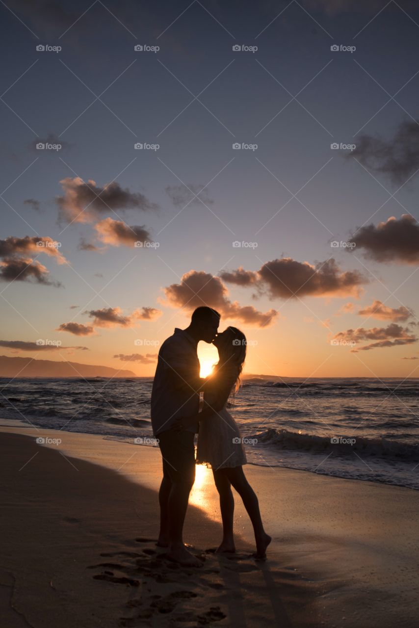 Silhouette of a young couple in love at sunset