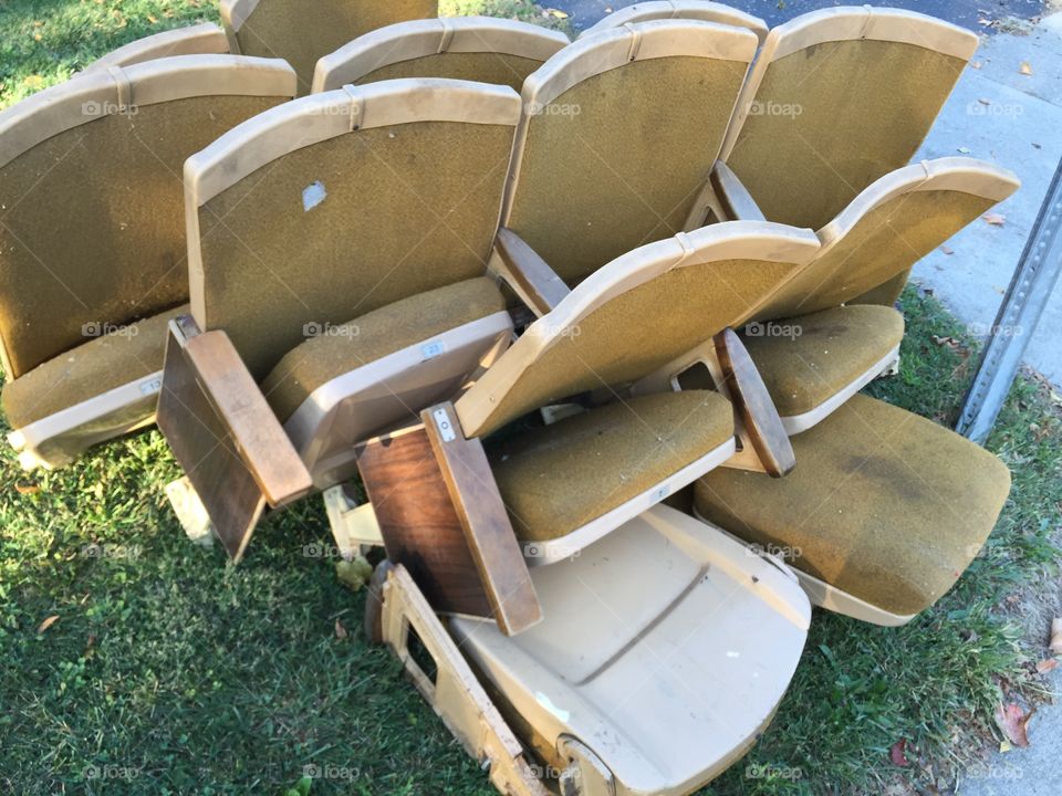 Old movie theater seats on the side of the road. 