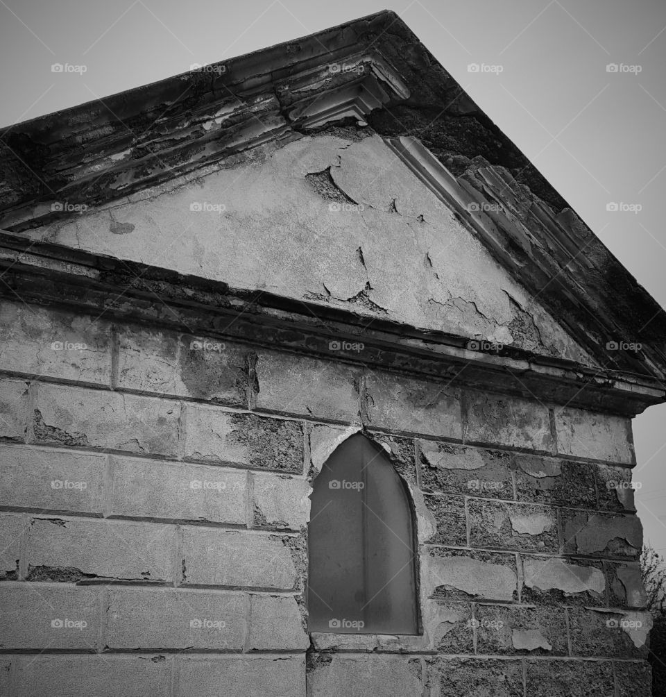 This a more darker, black and white picture of a  decaying family crypt in Santa Clara Mission Cemetery.