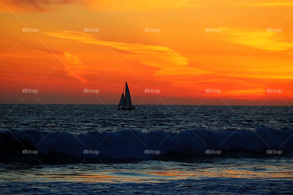 Silhouette of sailboat in the sea at sunset