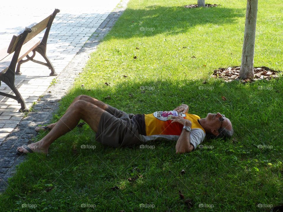 elderly man resting on the grass