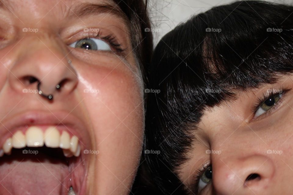 parte del rostros de dos adolescentes de la nueva era con piercing