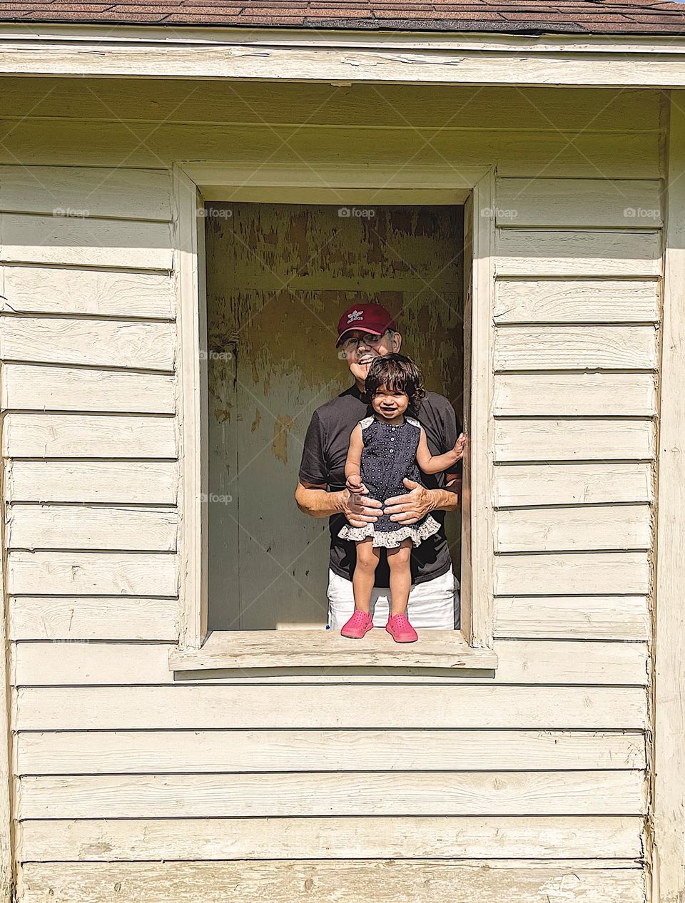 Grandpa and baby stand at window in abandoned building, Grandpa and baby at the window, baby spends time with grandparents, baby and Grandpa in old abandoned window, abandoned buildings and broken windows, windows with no glass