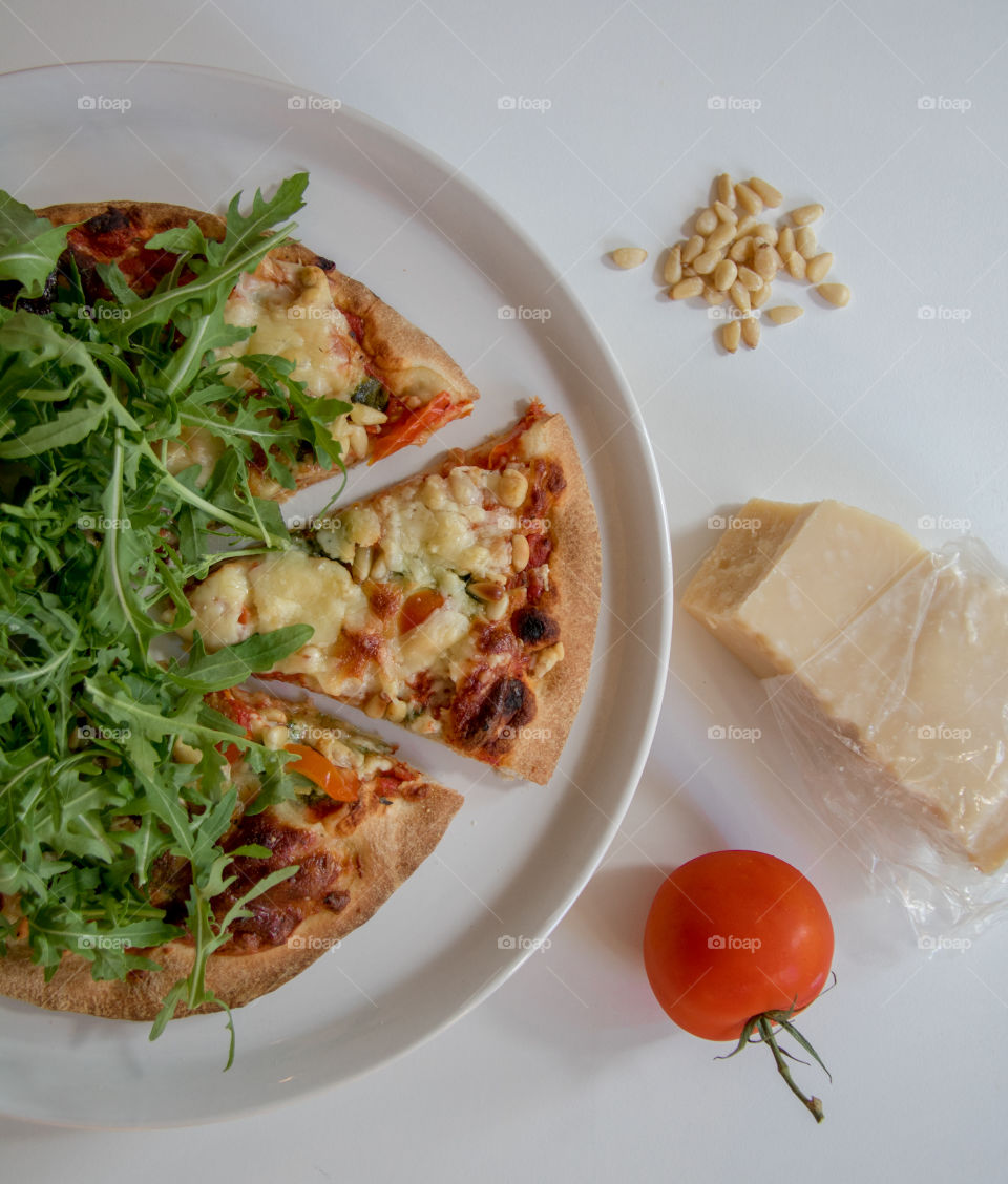 Hot pizza fresh out of the oven topped with arugula 