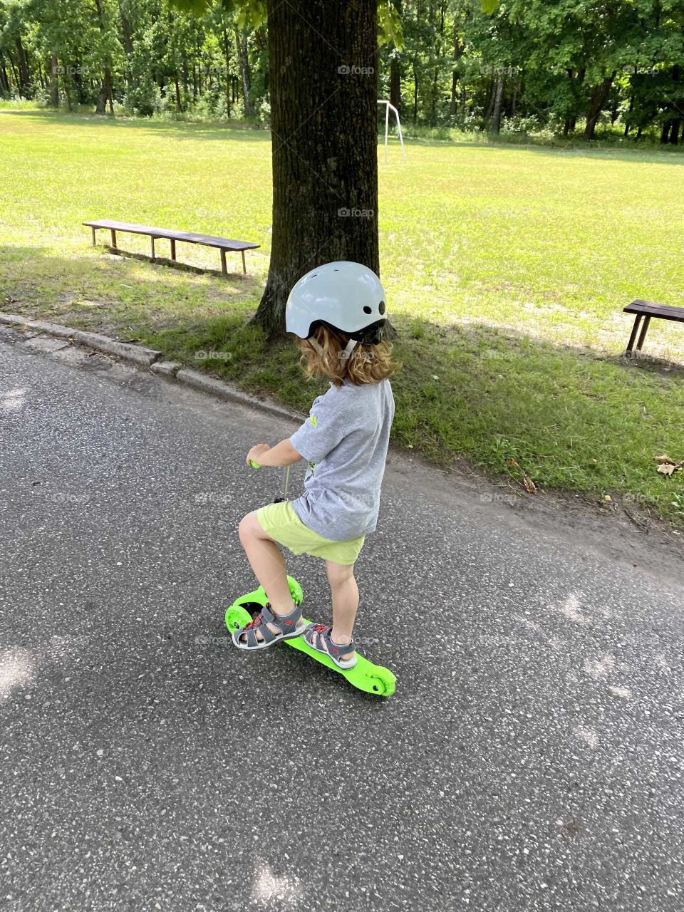 Little boy riding on a scooter