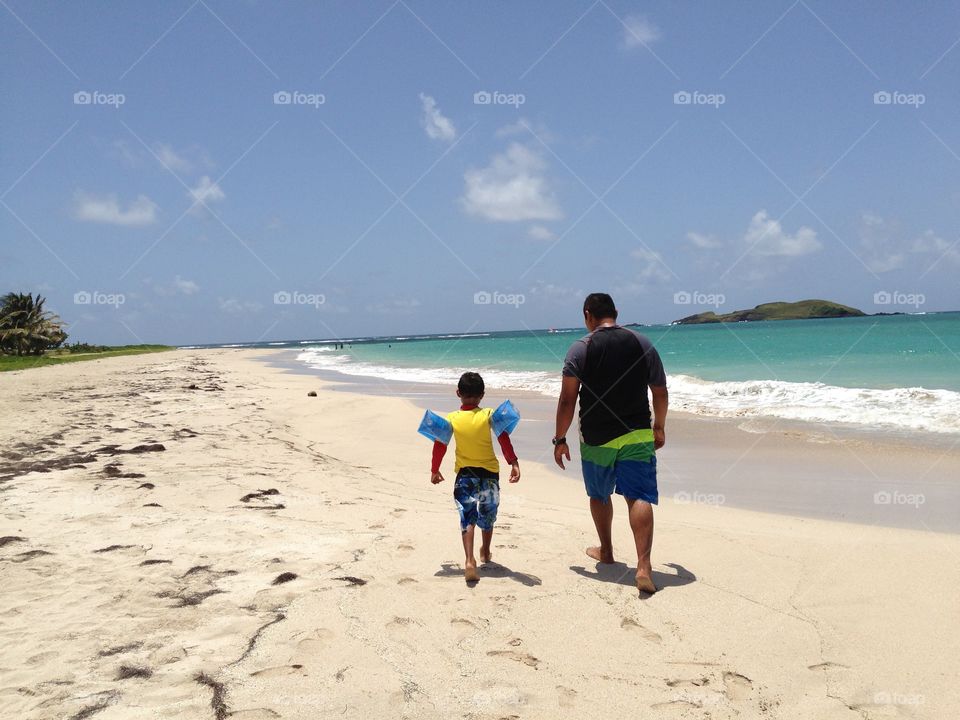 Father and son walking on the beach 