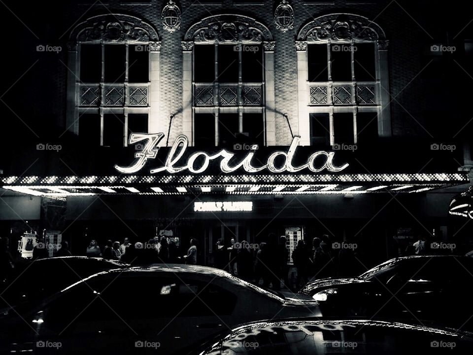 The historic Florida theater in downtown Jacksonville, Florida with neon sign lit up at night as seen from the street in black and white 