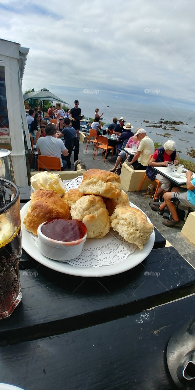 scones and jam on plate in cafe in sunny cliff top
